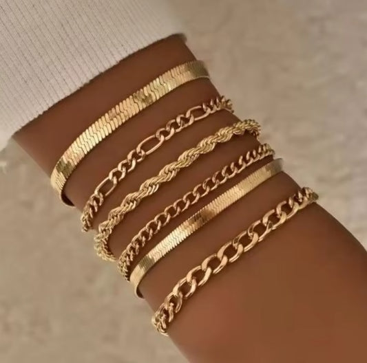 Juego de brazaletes dorados elegantes sobre fondo neutro

